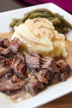 a white plate topped with meat and mashed potatoes