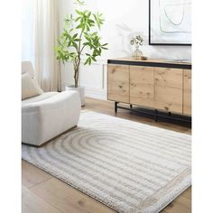 a living room with a white rug and wooden furniture