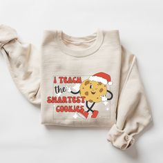 Teacher Christmas Sweatshirt Christmas Teacher Shirt Retro Christmas Teacher Sweater Teaching Team Party Shirt Smartest Cookies Teacher Gift ABOUT: :) This pre-shrunk, classic fit sweatshirt is made with air-jet spun yarn for a soft feel and reduced pilling. :) Pre-shrunk :) Classic fit with no center crease :) 1x1 athletic rib knit collar with spandex :) Air-jet spun yarn with a soft feel and reduced pilling :) Double-needle stitched collar, shoulders, armholes, cuffs, and hem: 50% preshrunk cotton, 50% polyester and like colors. SIZING: :) The sweater used is the Gildan 18000 Unisex Heavy Blend Crewneck Sweatshirt :) Sweatshirts are UNISEX so please refer to sizing chart in photos CARE INSTRUCTIONS: :) Garments should be machine-washed cold, inside-out on a gentle cycle with a mild deter Cute Holiday Daycare Shirts, Team Party, Photo Care, Smart Cookie, Teacher Christmas, Workout Sweatshirt, Deep Colors, Party Shirts, Christmas Sweatshirts