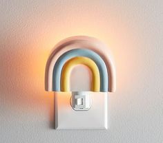 a light that is on the wall and has a rainbow shaped light in front of it