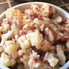 a white bowl filled with potato salad on top of a table