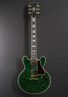 a green guitar hanging on the wall