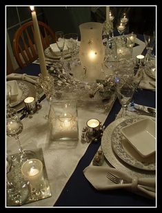 the table is set with silverware and candles