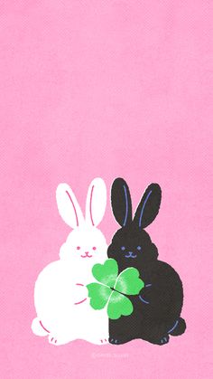 two rabbits are sitting next to each other with clover leaves in their paws on a pink background