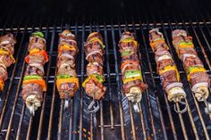 several skewered meats are being cooked on the grill