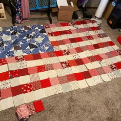 an american flag quilt is laying on the floor next to some boxes and other items