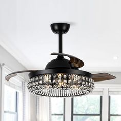 a black ceiling fan with crystal chandelier hanging from it's blades