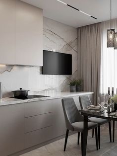 a dining room table with chairs and a television mounted on the wall in front of it