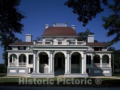 a large white house sitting on top of a lush green field