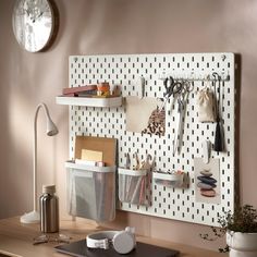 a white pegboard mounted to the side of a wall with office supplies on it