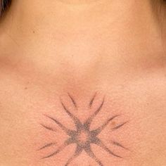 a woman's chest with an intricate tattoo design on the back of her neck