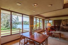 a living room with large windows and wooden furniture