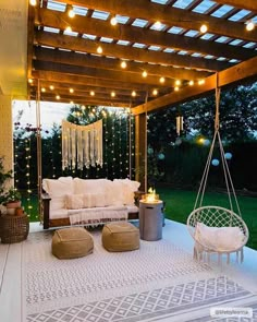 an outdoor living area with white furniture and string lights