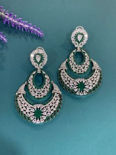 American diamond earring tikka set in black Victorian polish. Comes with a tikka. Available in 3 different color. Two of which is black polished . One set has ruby retails and one is clear. about 3 inch long and one and half in width. Tikka is about one inch long. Silver Chandbalis For Reception, Elegant Green Chandbalis For Eid, Elegant Silver Danglers For Eid, Fusion Style Hand Set Chandelier Earrings For Party, Elegant Festive Tikka With Cubic Zirconia, Elegant Kundan Chandelier Earrings, Elegant Festive Cubic Zirconia Tikka, Eid Hand Set Silver Earrings, Fusion Style Party Chandbalis With Hand Set