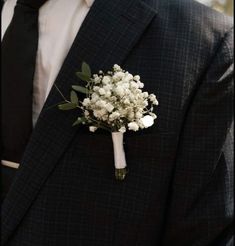 a man in a suit and tie holding a boutonniere