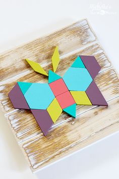 an origami bird sitting on top of a wooden board