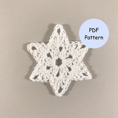 a white crocheted snowflake on a gray background