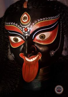 a mask with an orange tongue sticking out of it's mouth and black hair