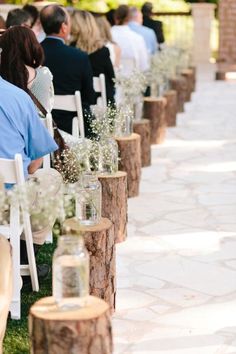 a row of chairs with flowers and mason jars sitting on top of them in front of an audience