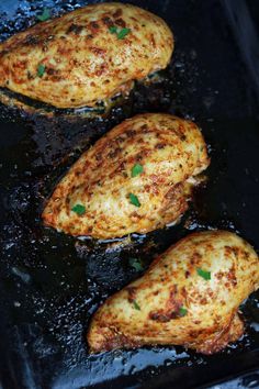 three pieces of chicken cooking in a pan