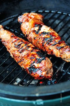 two pieces of meat are being grilled on a grill