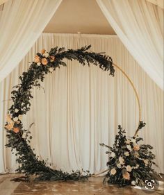 a wedding arch decorated with flowers and greenery for the entrance to the ceremony room