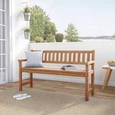 a wooden bench sitting on top of a hard wood floor next to a white wall