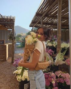 a woman is holding flowers in her hands