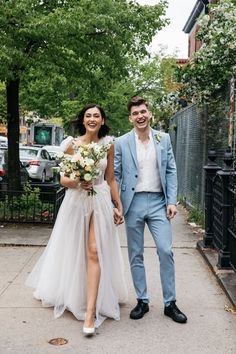 a bride and groom walking down the street