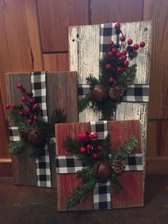 three wooden blocks decorated with christmas decorations and pine cones on the top one is red, black and white plaid