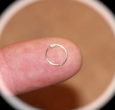 a finger with a tiny ring on it