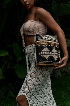 Balinese bag in ethnic pattern made with bamboo and wood, decorated with beige and black beads, shells and rope handle. Each bag is entirely crafted by hand in the Ubud region. Bring a chic ethnic vibe to your home with this unique Balinese bag! To be used as storage box or simply as an element of décor. Each product is carefully handcrafted by Balinese artisans with natural and sustainable materials. Composition: bamboo, beads, cowrie shells, wood, rope Dimensions: H 27 x W 9 x L 22 Origin: Bali Each item is unique! The products are made by hand and may slightly differ in color and size. PLEASE ADD YOUR E-MAIL ADDRESS AND YOUR PHONE NUMBER TO EVERY ORDER UNDER COMMENTS SECTION. THIS IS REQUIRED FOR DELIVERY PURPOSES. Bohemian Black Straw Bag For Vacation, Black Bohemian Straw Bag For Vacation, Beige Beaded Crochet Bag For Beach, Beaded Brown Shoulder Bag For The Beach, Bohemian Beaded Rectangular Beach Bag, Bohemian Black Beaded Shoulder Bag, Natural Beaded Crochet Rectangular Bag, Beaded Brown Shoulder Bag For Vacation, Bohemian Beaded Crochet Bag In Natural Color