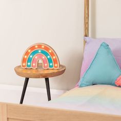 a wooden bed topped with pillows and a neon sign on top of the headboard