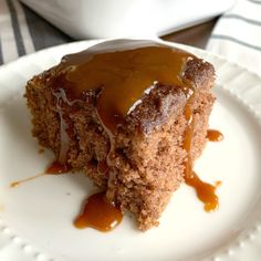 a piece of cake on a plate with caramel sauce drizzled over it