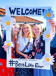 three girls holding up a sign with the words best life ever written in front of them