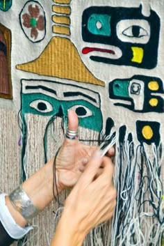 a woman is working on a piece of art with her hands and fingernails