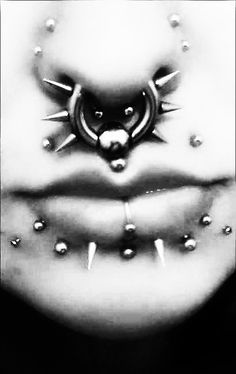 a black and white photo of a woman's face with spikes on her stomach