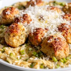 a white plate topped with meatballs covered in grated parmesan cheese and peas