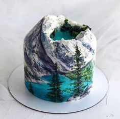 there is a cake decorated with trees and mountains