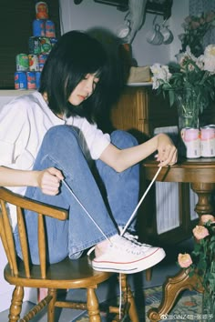 a woman sitting on top of a wooden chair