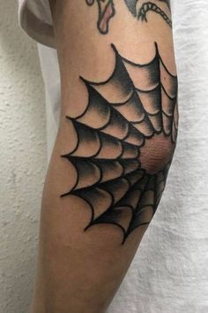 a spider web tattoo on the arm