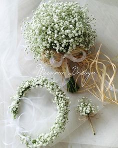 a bouquet of baby's breath sits next to the wedding ring and boutonniere