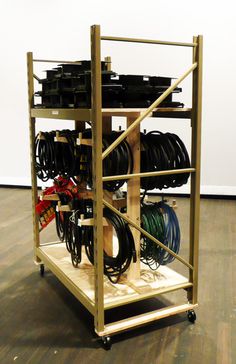 a rack filled with lots of wires and hoses on top of a hard wood floor