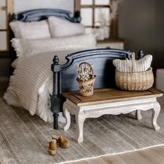 a dollhouse bedroom with a bed, foot board and basket sitting on the floor