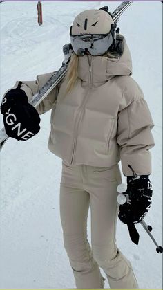 a woman is holding her skis in the snow