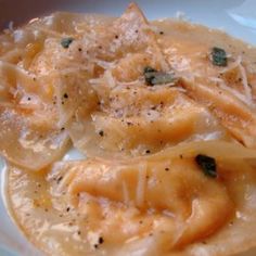 two ravioli with cheese and herbs on a white plate