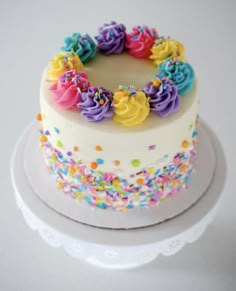 a white cake with colorful frosting and sprinkles