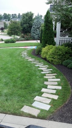 a stone path in the middle of a lawn