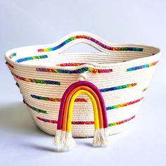 a white basket with a rainbow painted on it