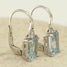 -18k white gold, aquamarine and diamond earrings. -Precious dangling earrings in 18 k white gold, natural emerald cut aquamarine embellished with brilliant cut diamonds, sturdy leverback lacing. -Handcrafted jewel of Italian manufacture. -Very refined and elegant earrings, with high quality aquamarines, a beautiful sky-blue color, and very bright diamonds. -FEATURES 18 k white gold, 2.60 ctw aquamarine, 0.04 ctw diamonds. Height: 1.8 cm (0.70 inches). Width: 0.7 cm (0.28 inches). Weight: 3 grams White Gold Drop Earrings With Blue Topaz, White Gold Blue Topaz Drop Earrings, Modern Light Blue Earrings Gift, Elegant Aquamarine Nickel-free Earrings, Light Blue Aquamarine Drop Earrings, Earrings Emerald, Aquamarine Earrings, Diamond Dangle Earrings, Italian Jewelry